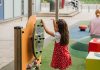 Child playing with educational outdoor playground equipment.